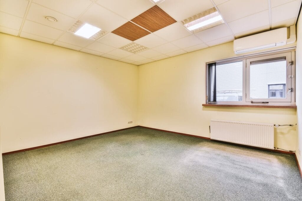 An Empty Room With A Window And A Ceiling Lights