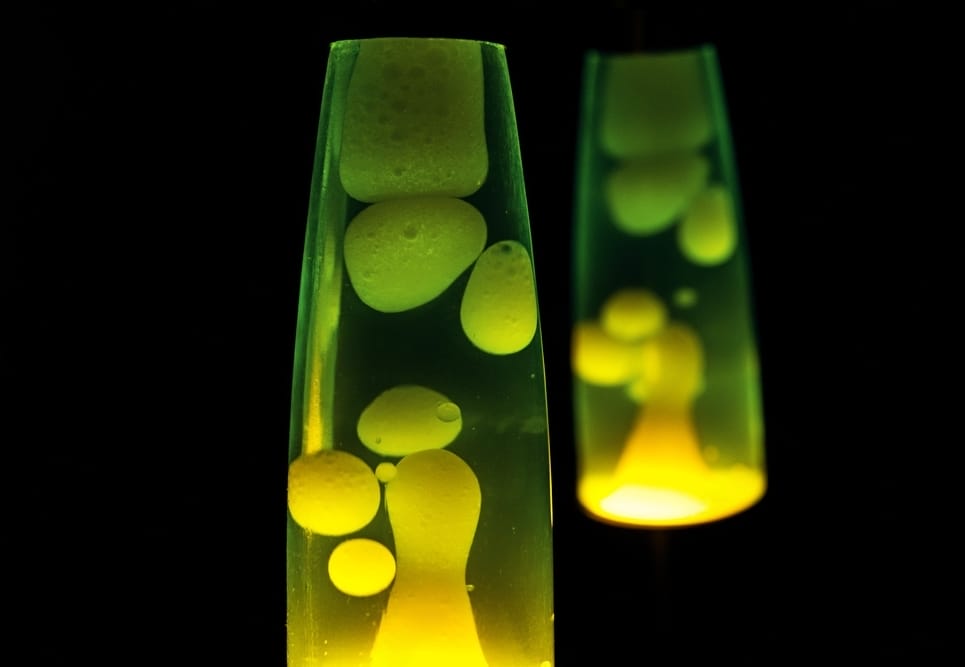 A glowing neon green and yellow lava lamp is left to illuminate the dark surroundings.