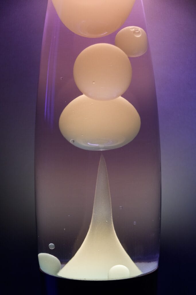 a lava lamp with a milky white light on a gradient background