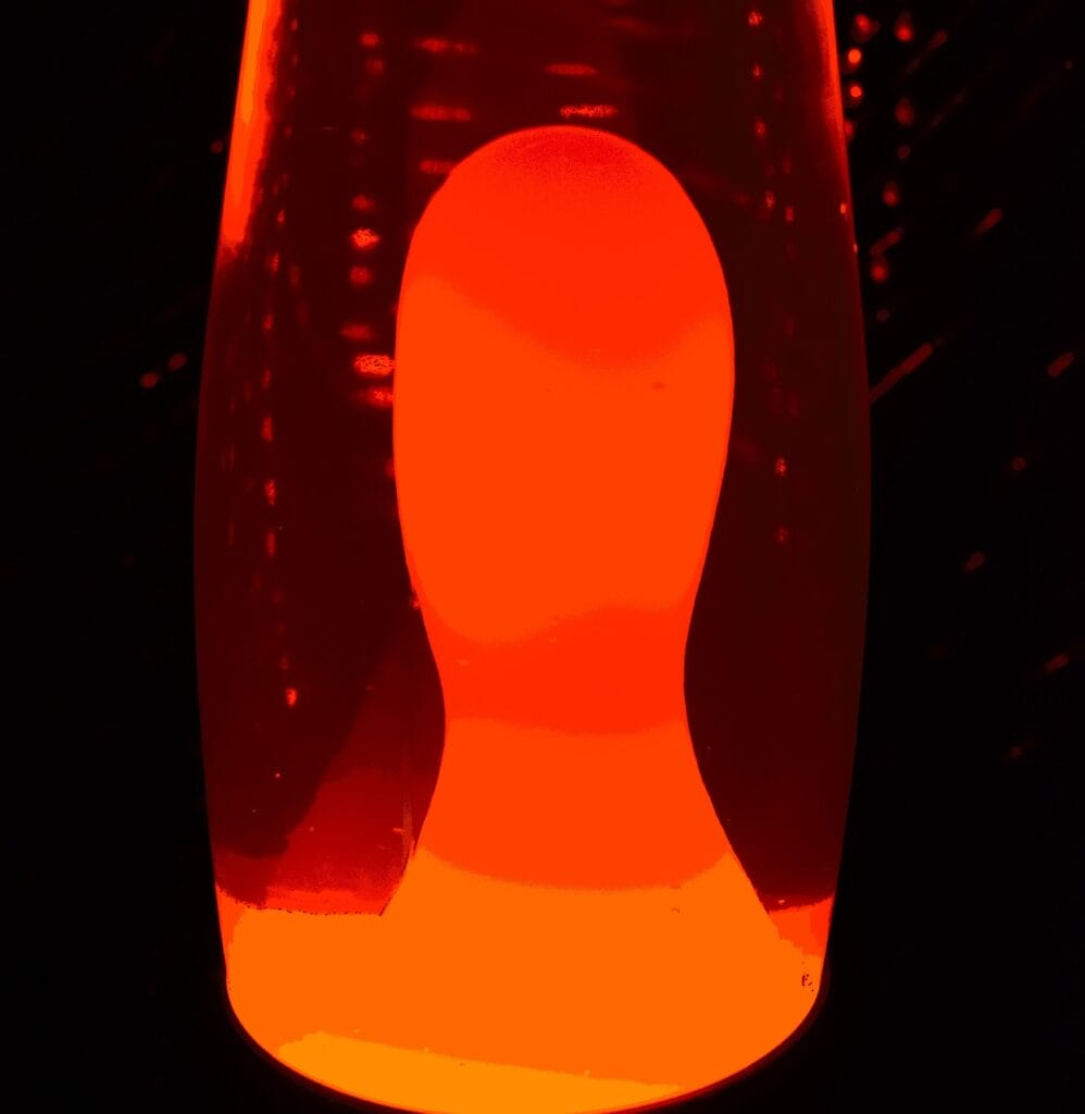 a lava lamp with red-orange color light on a dark background