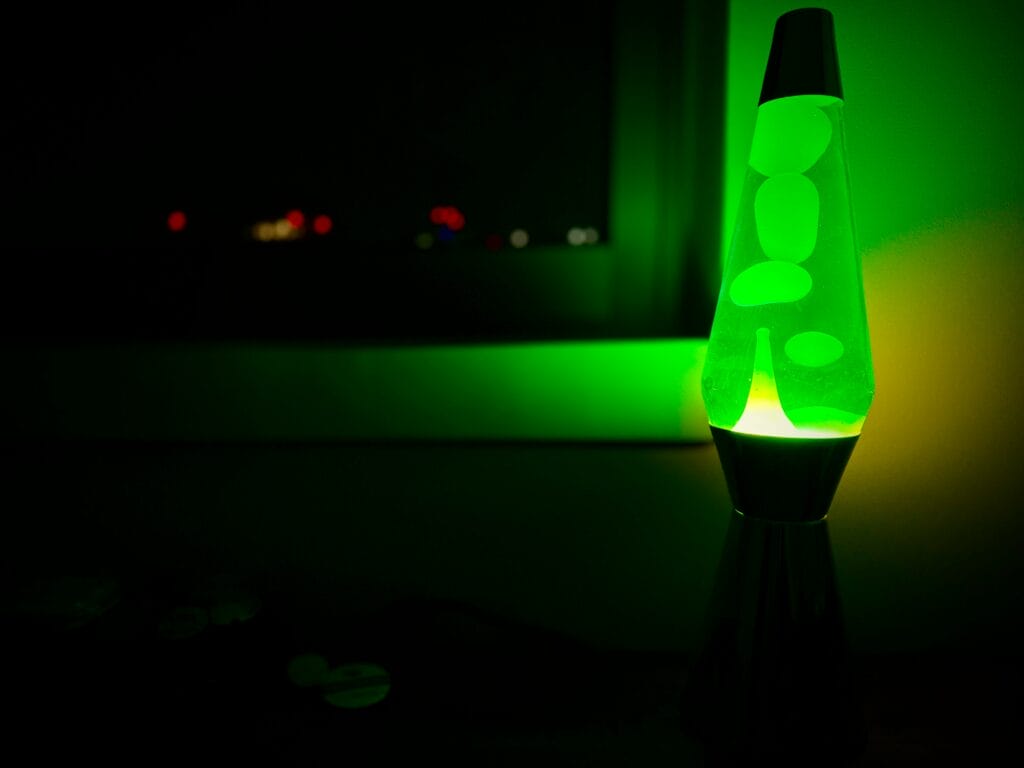 A green lava lamp placed on a flat leveled surface.